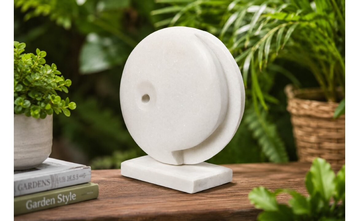 Modern white marble abstract sculpture displayed in a stylish garden setting with natural greenery and contemporary outdoor decor.