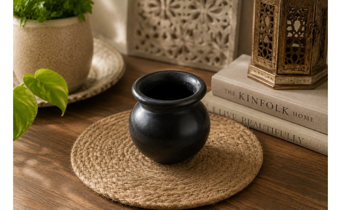 Black decorative clay matki placed on a wooden table in a modern home decor setting.