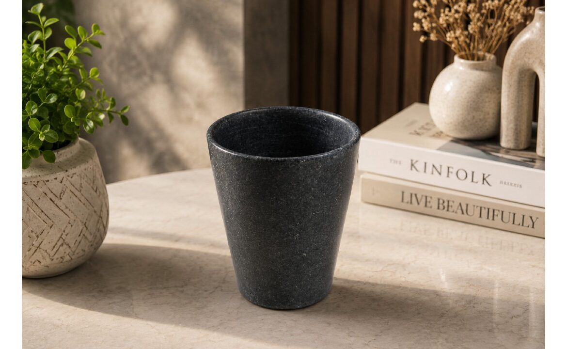 Elegant black marble flower vase displayed on a modern tabletop with decorative books and ceramic vases, perfect for luxury home décor.