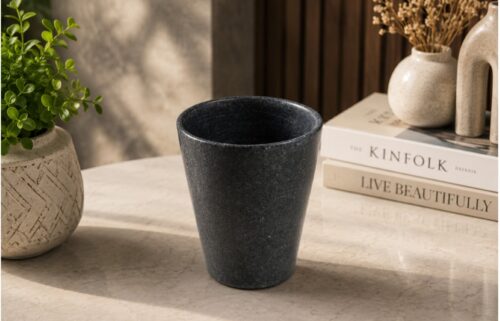 Elegant black marble flower vase displayed on a modern tabletop with decorative books and ceramic vases, perfect for luxury home décor.