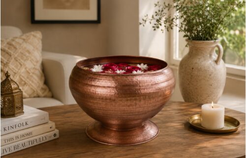 Handcrafted hammered copper decorative bowl styled on a modern living room coffee table with elegant home decor.